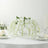 White floral centerpiece with cascading orchids on a dining table.