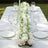Elegant floral table centerpiece with candles and glassware for a dining setting.