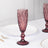 Purple crystal champagne flute on a white table with elegant dining setup.