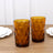 Amber geometric glasses on a wooden table.