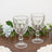 Set of two elegant crystal goblets on a wooden table with greenery.