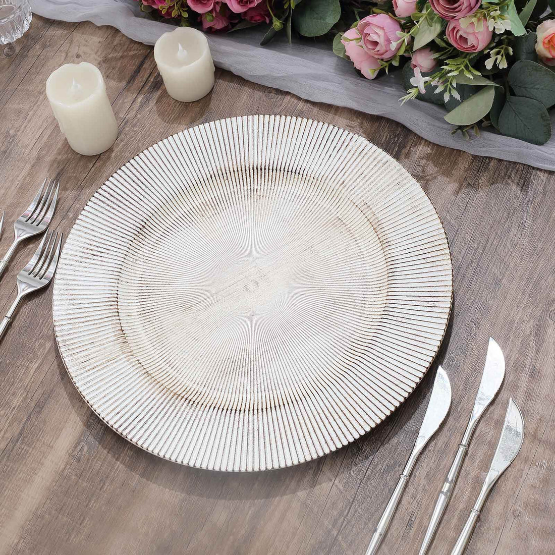 Elegant round plate with textured design on wooden table, surrounded by candles and flowers.