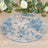 Blue floral decorative plate on a wooden surface with greenery and roses.