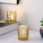 Gold decorative candle holder with intricate design on a minimalist tabletop.