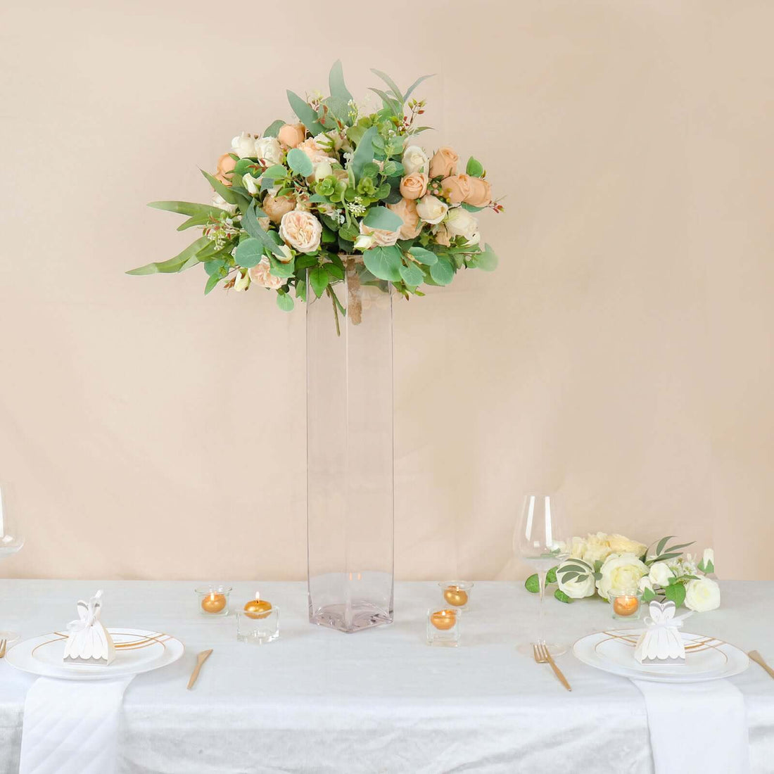 Elegant floral arrangement in a tall vase on a dining table.