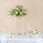 Elegant floral arrangement in a tall vase on a dining table.