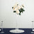White rose bouquet in a tall glass vase on a table setting.