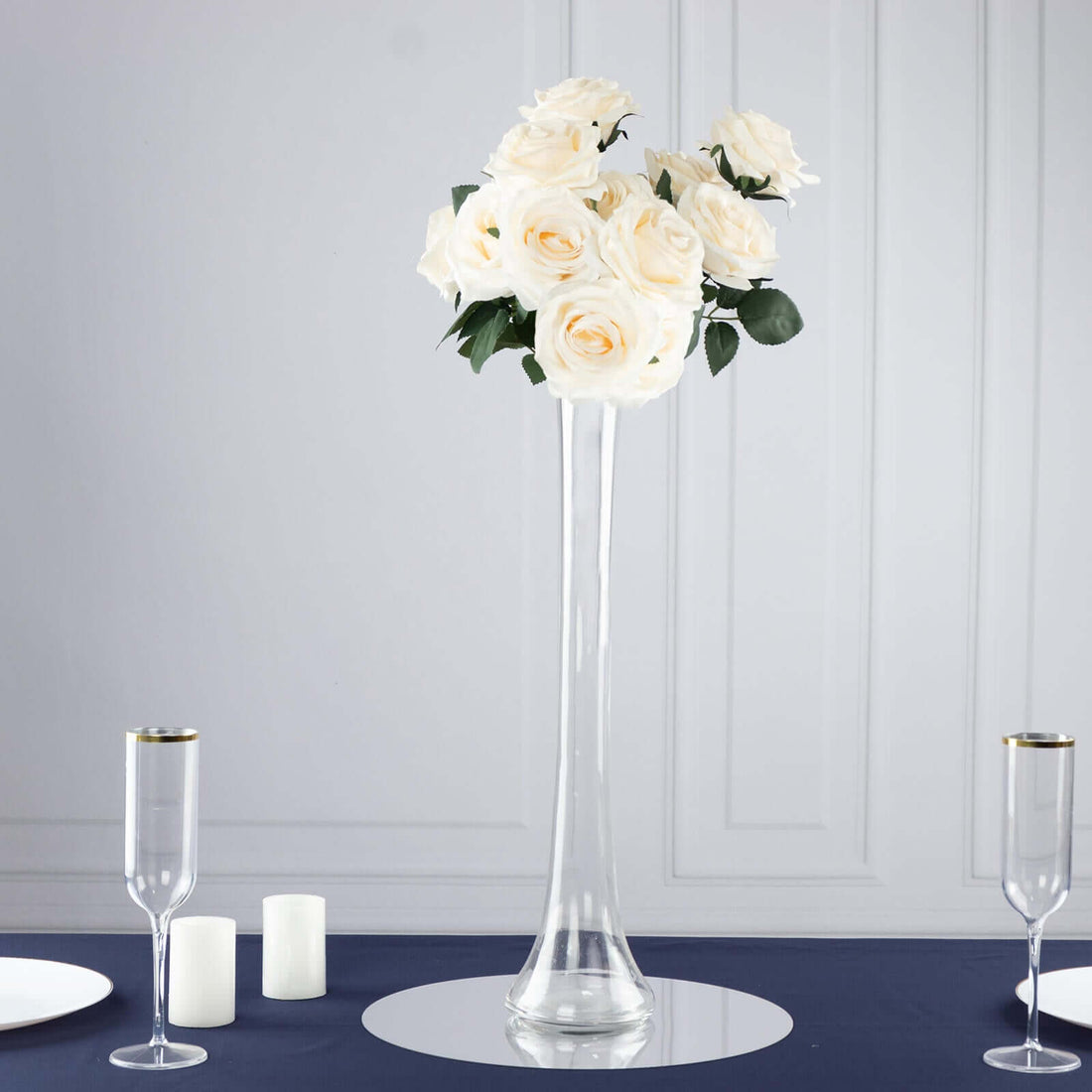Elegant white rose floral arrangement in a tall glass vase.
