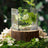 Clear glass vase with flowers on a wooden stump surrounded by greenery.