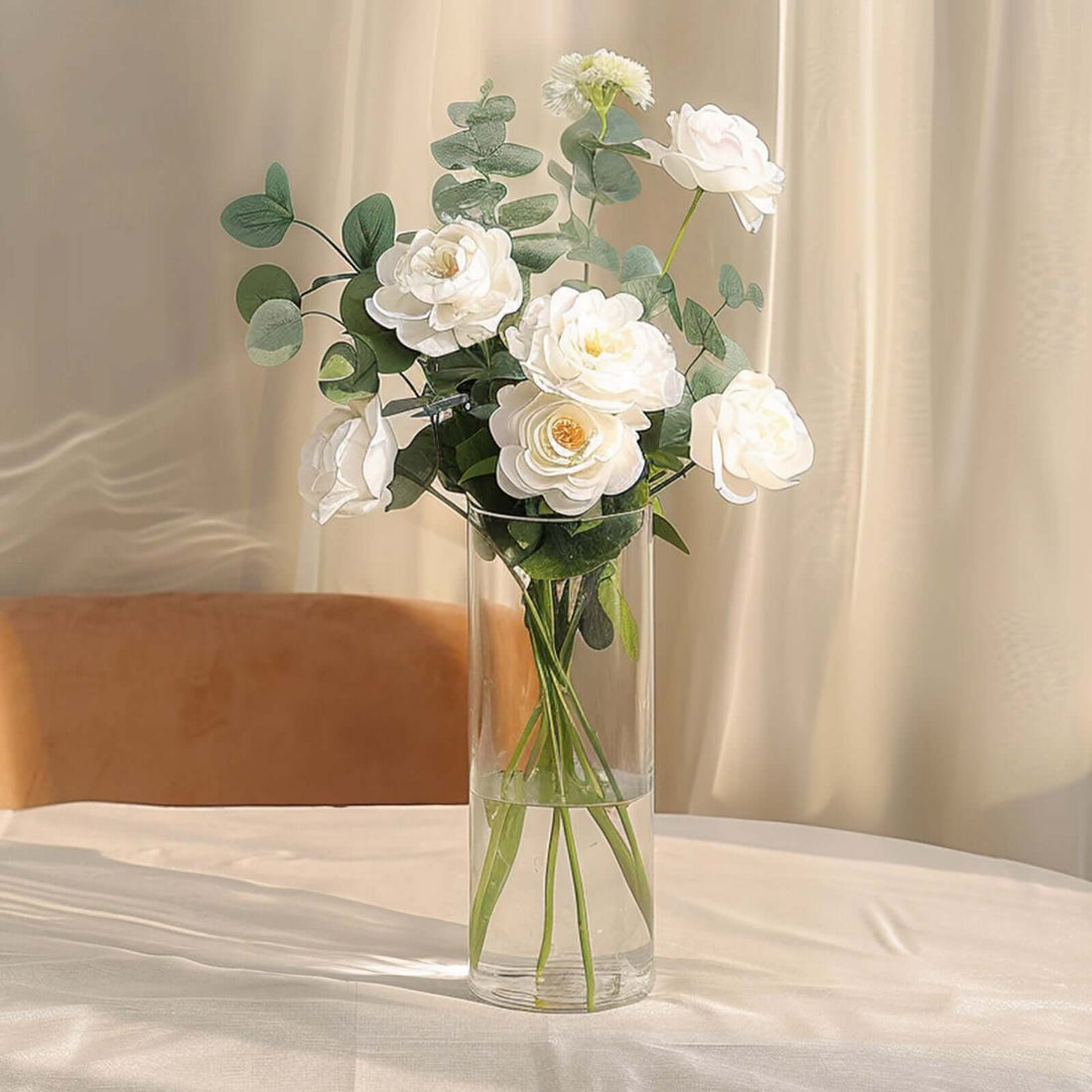 Elegant white flower bouquet in a clear vase on a table.