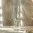 Elegant tall glass vase with water and floral accents.