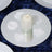 Candle centerpiece with white petals on a mirrored plate