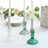 Elegant green and clear glass candle holders with white candles.