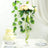 Elegant floral arrangement in a tall vase on a table with a wedding cake.