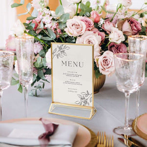 Elegant wedding menu displayed with floral centerpiece and table setting.