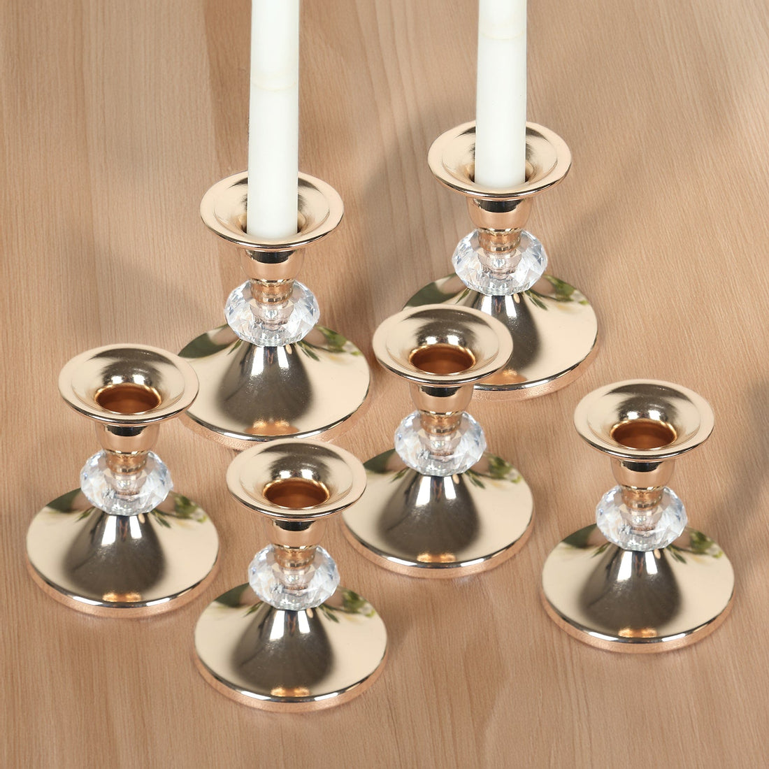 Set of elegant rose gold candle holders with crystal accents.