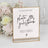 Photo guestbook sign with playful text and camera icon on a display stand.