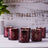 Set of six decorative burgundy candles with intricate designs.