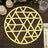 Geometric gold placemat on a wooden table.