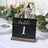 Table number sign with elegant silver lettering on a black background.