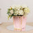 Pink flower arrangement in a gold-accented container.
