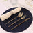 Elegant gold cutlery set on a navy glitter placemat with a rolled napkin.