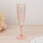 Elegant pink crystal champagne flute on a wooden surface.
