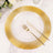 Gold-rimmed clear plate with cutlery on a marble surface.