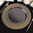 Elegant black plate with golden dotted rim on black table setting.