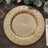 Gold decorative charger plate with intricate floral design.