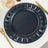 Navy blue decorative charger plate with leaf design accents.