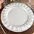 Elegant silver charger plate with embossed design, perfect for dining decor.