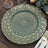 Decorative teal and gold patterned serving platter on a wooden table.