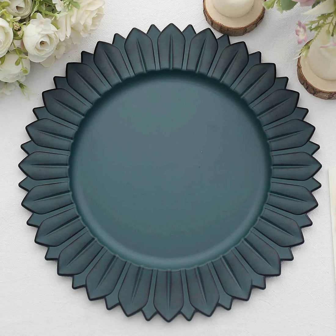 Teal decorative plate with petal design on a white background.