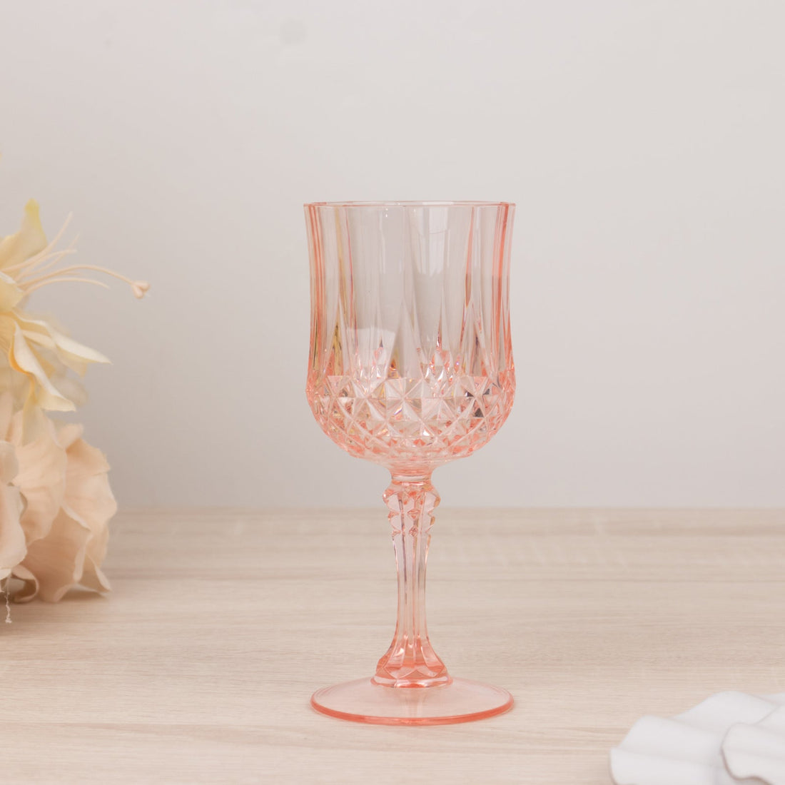 Pink crystal wine glass with a diamond pattern and elegant stem.