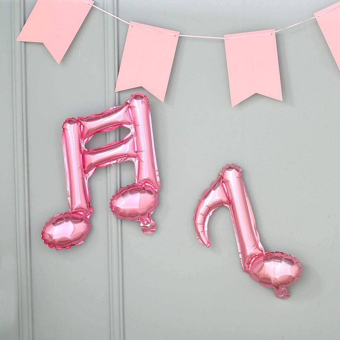Pink musical note balloons hanging with decorative pink banners.