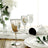 Elegant silver stemmed wine glass with table setting and floral arrangement.