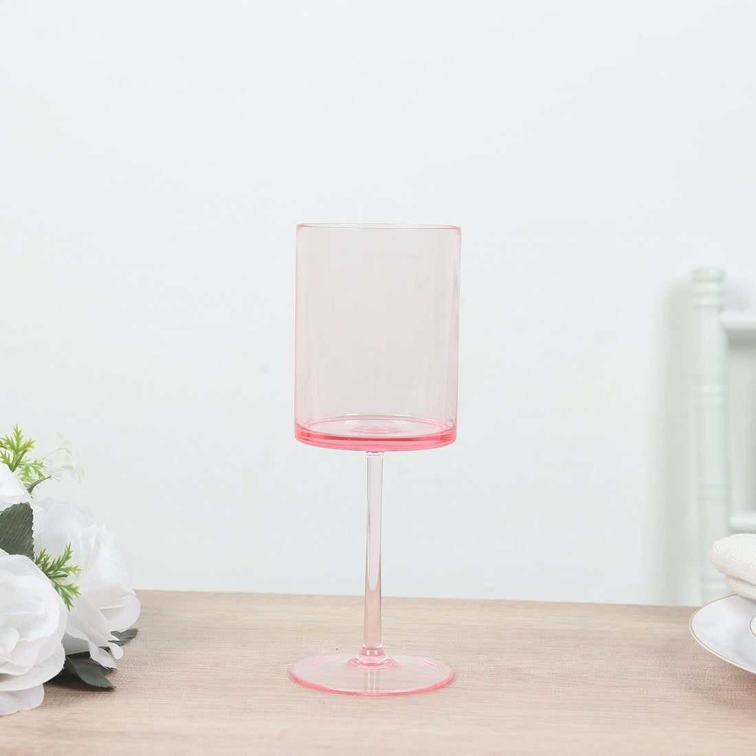 Pink transparent wine glass on a plain background.