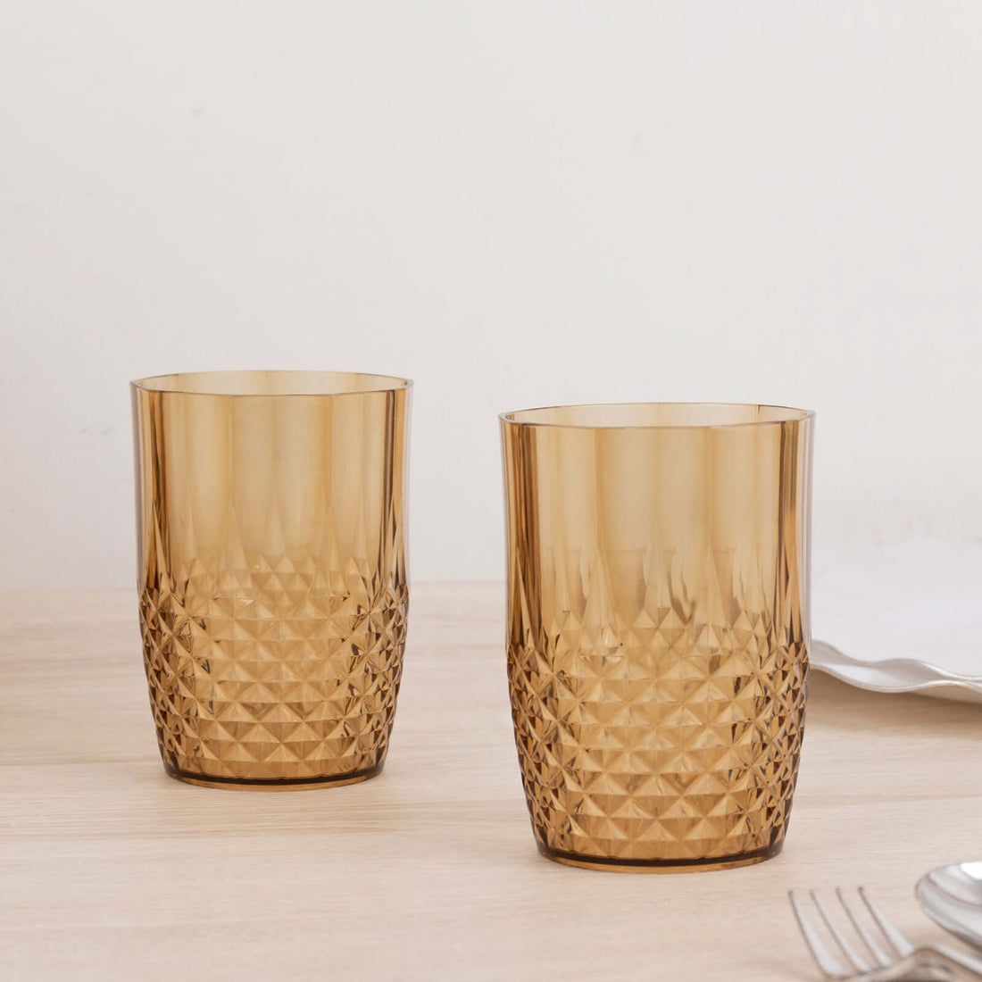 Amber patterned drinking glasses on a wooden table.