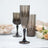 Elegant smoked glass champagne flutes with intricate patterns and black stems.