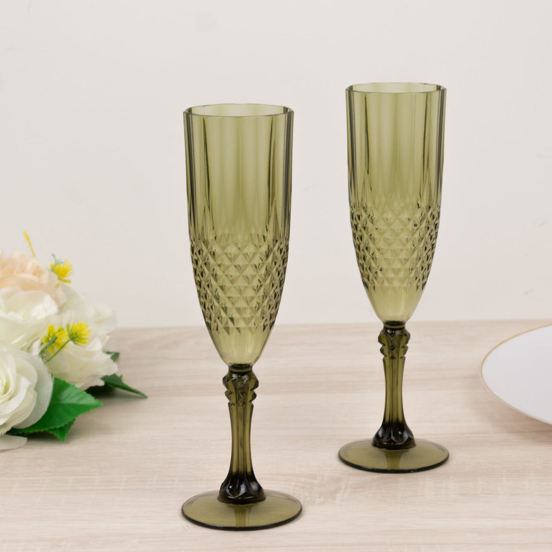 Green glass champagne flutes with diamond pattern design.