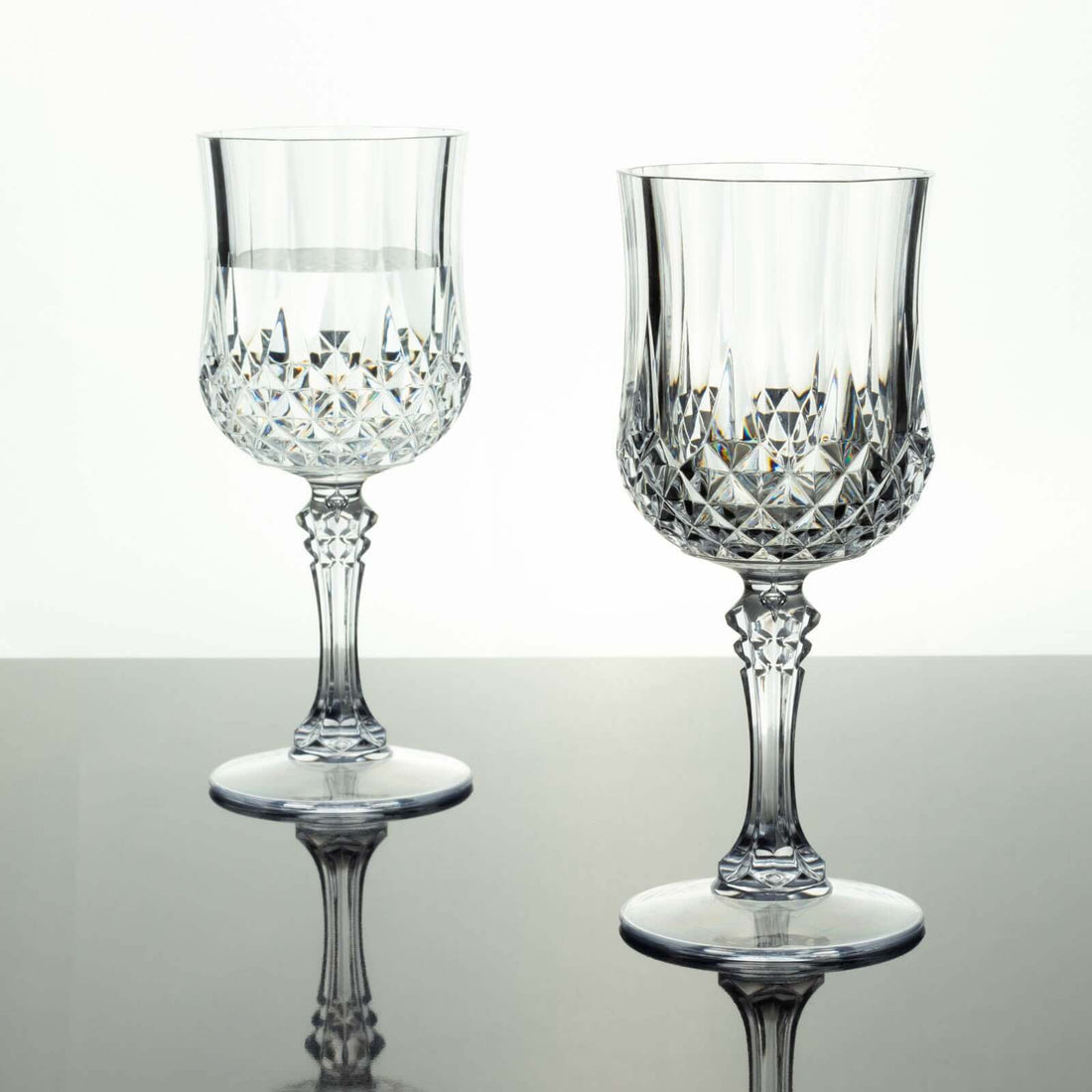 Crystal wine glasses with intricate cut designs, reflecting light elegantly.