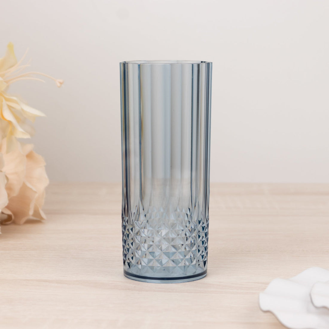 Blue textured glass vase on a light wooden surface.
