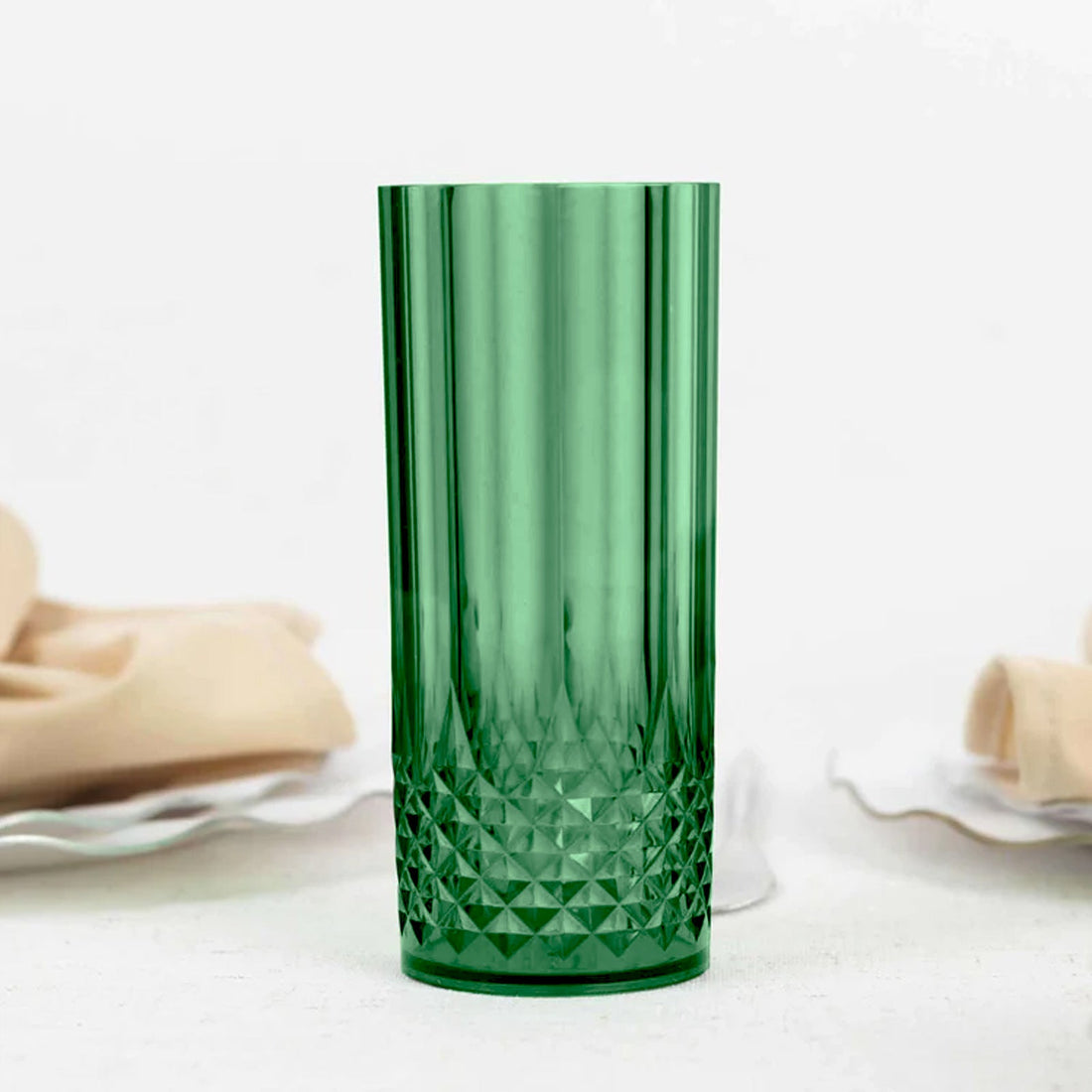 Green diamond-patterned drinking glass on a plain background.