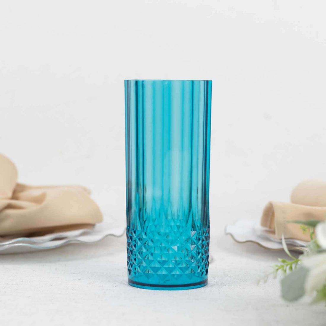 Blue crystal glass vase with textured design on plain backdrop.