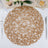 Round woven placemat in natural fibers on a table setting.