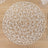 Round woven placemat in intricate geometric design on wooden surface.