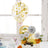 Colorful birthday cake decoration with confetti balloon and paper fans.