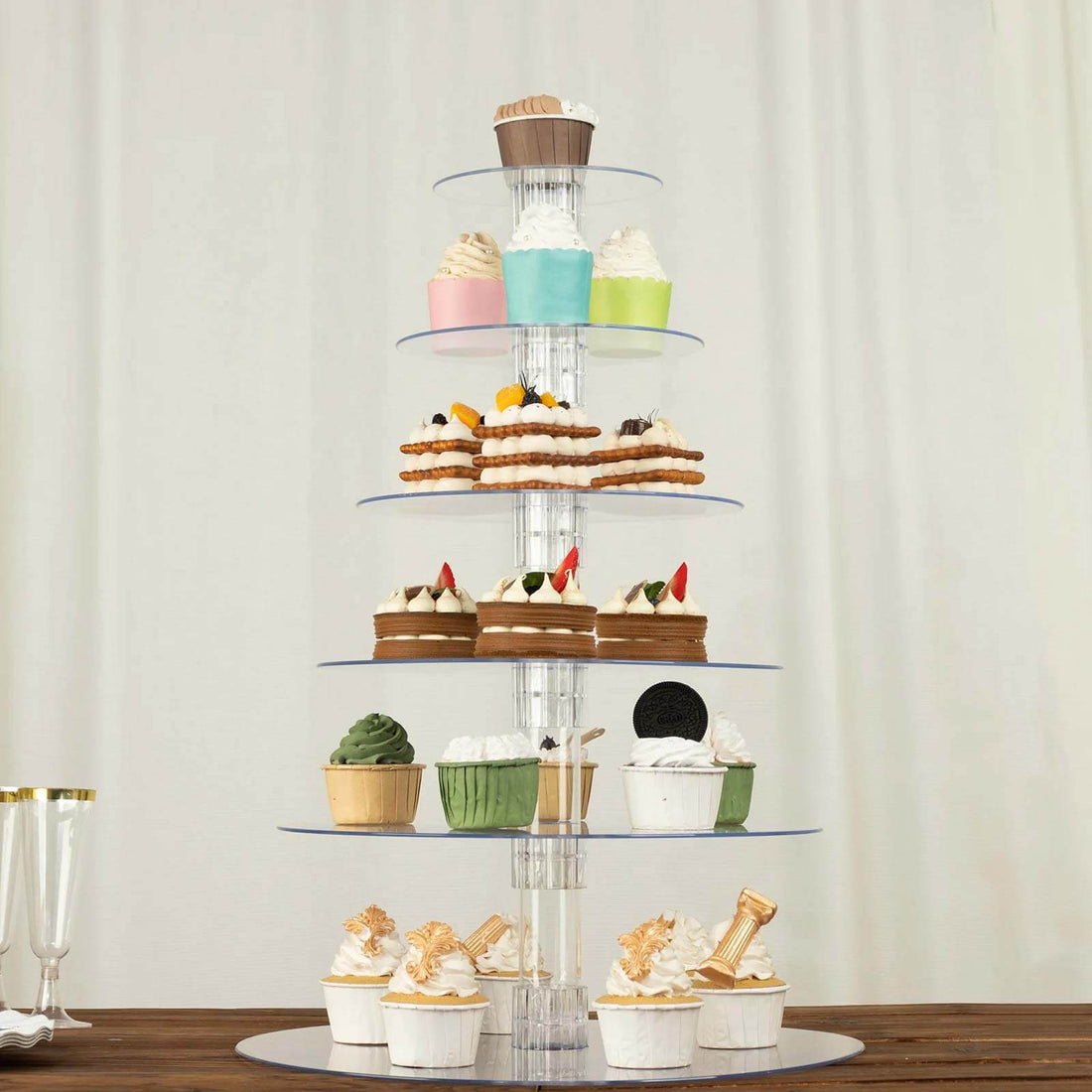 Cupcake display stand with assorted cupcakes and desserts on multiple tiers.
