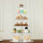 Cupcake display stand with assorted cupcakes and desserts on multiple tiers.